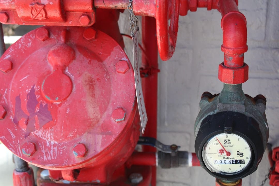 a-close-up-of-a-red-valve-with-a-clock-on-it-sixlksypty